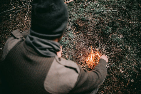 image of man starting a fire using flint and steel 