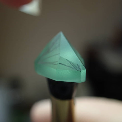 Example of ‘tracing’ pencil lines drawn on a gemstone to visualise where facets and meet points will be cut down. - Photo Credit: Tatum Gems