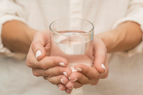 woman holding glass filled with water