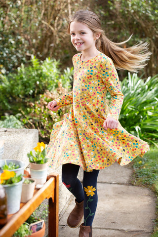 girl wearing a yellow skater dress made from organic cotton