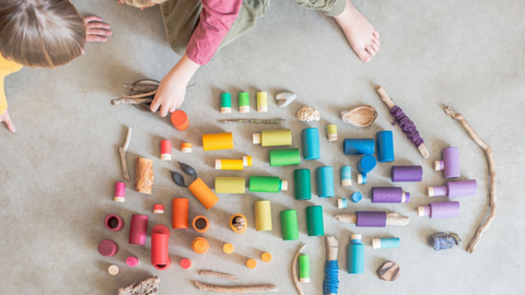 child playing on the floor with the Grapat Lola wooden play set