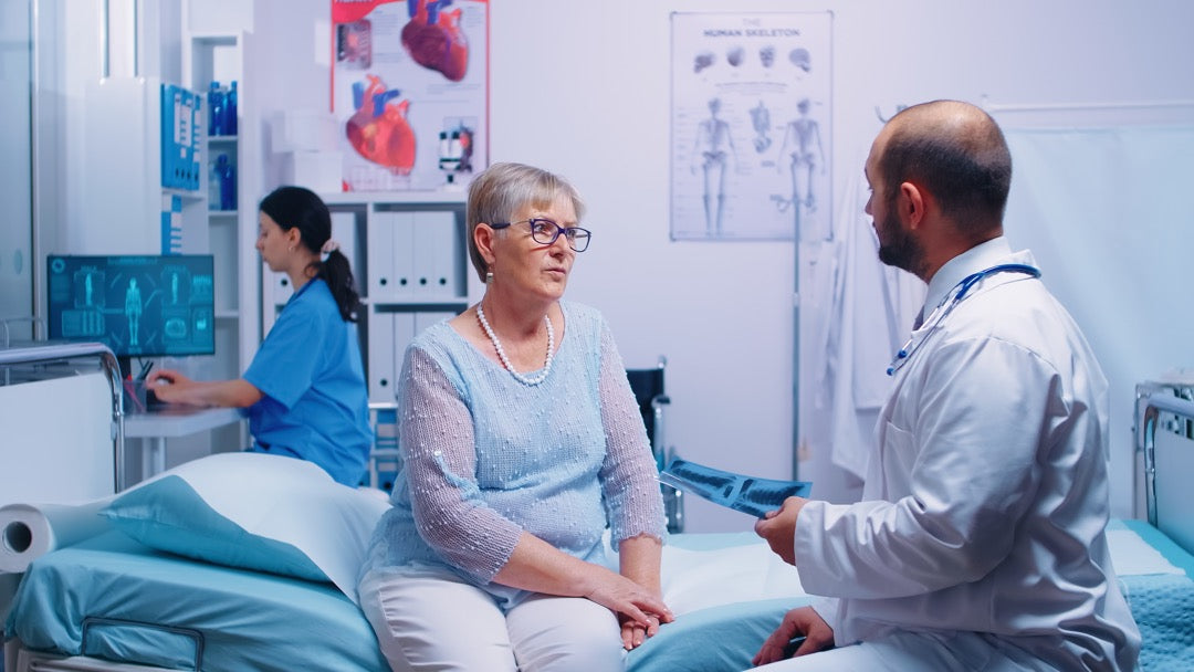 Radiology doctor looking at x-rays of senior woman in private clinic or hospital.