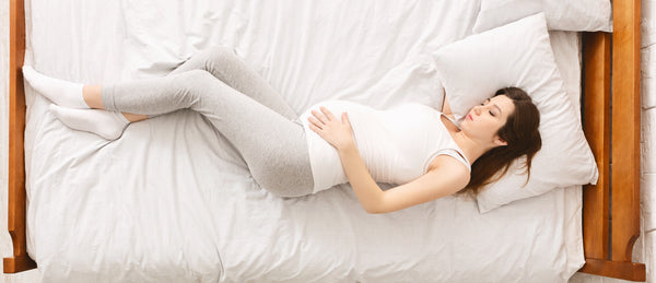 Young pregnant woman sleeping on her back