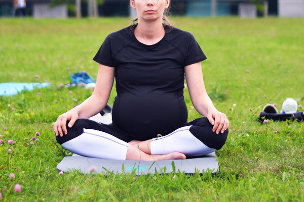Pregnant woman doing yoga sitting