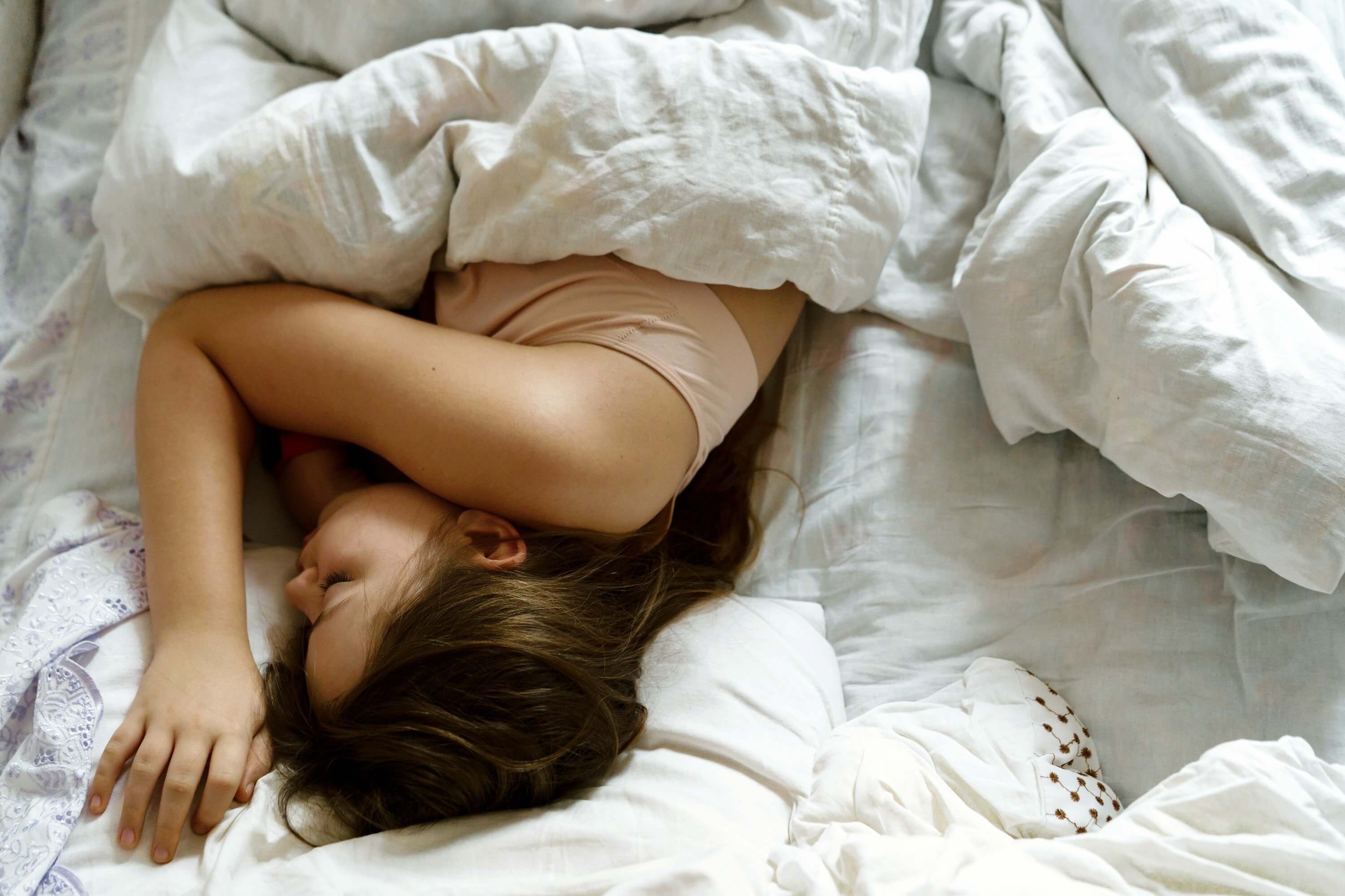 Woman sleeping on her side under a weighted blanket