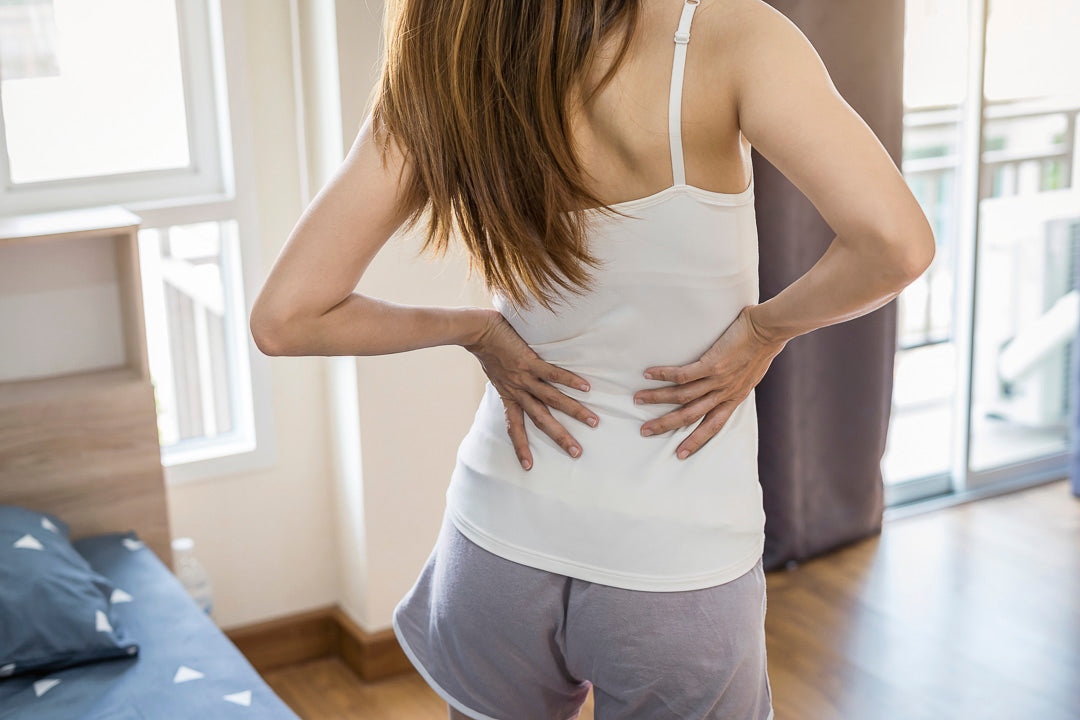 a woman with back pain after getting out of bed