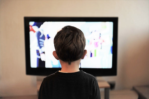 Petit garçon qui regarde la télé avant d'aller au lit