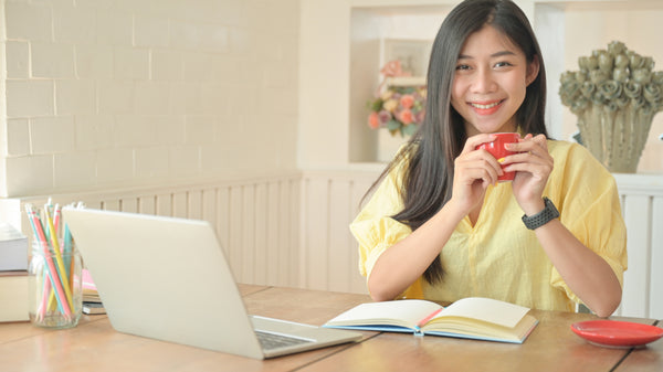 asian woman with a laptop working at home to prevent the spread of coronavirus