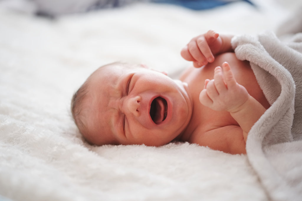 Newborn baby on a bed