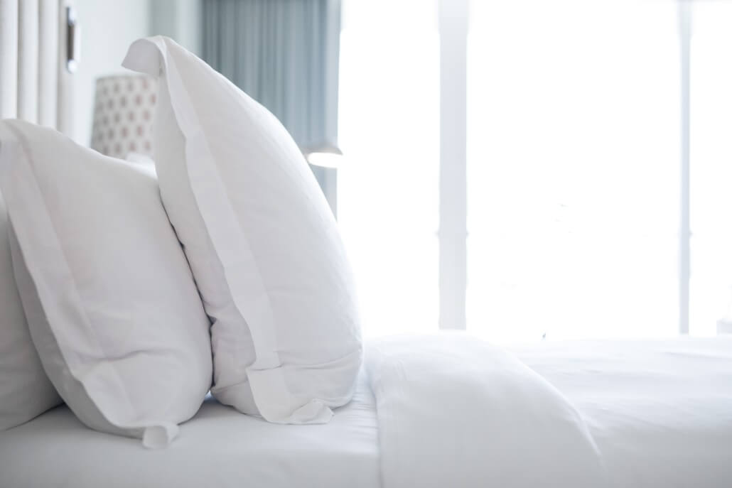 Side view of a bed with its white pillows