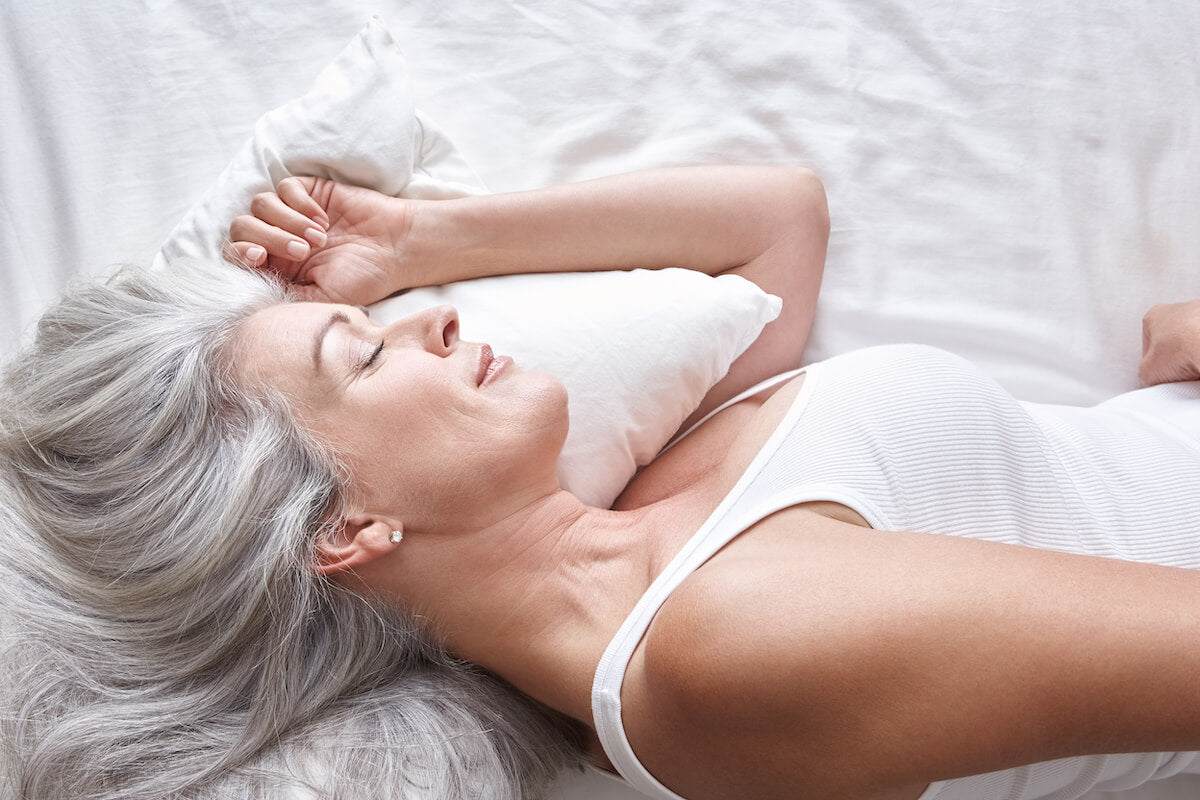 Comfortable woman sleeping on her side with her head on her pillow.