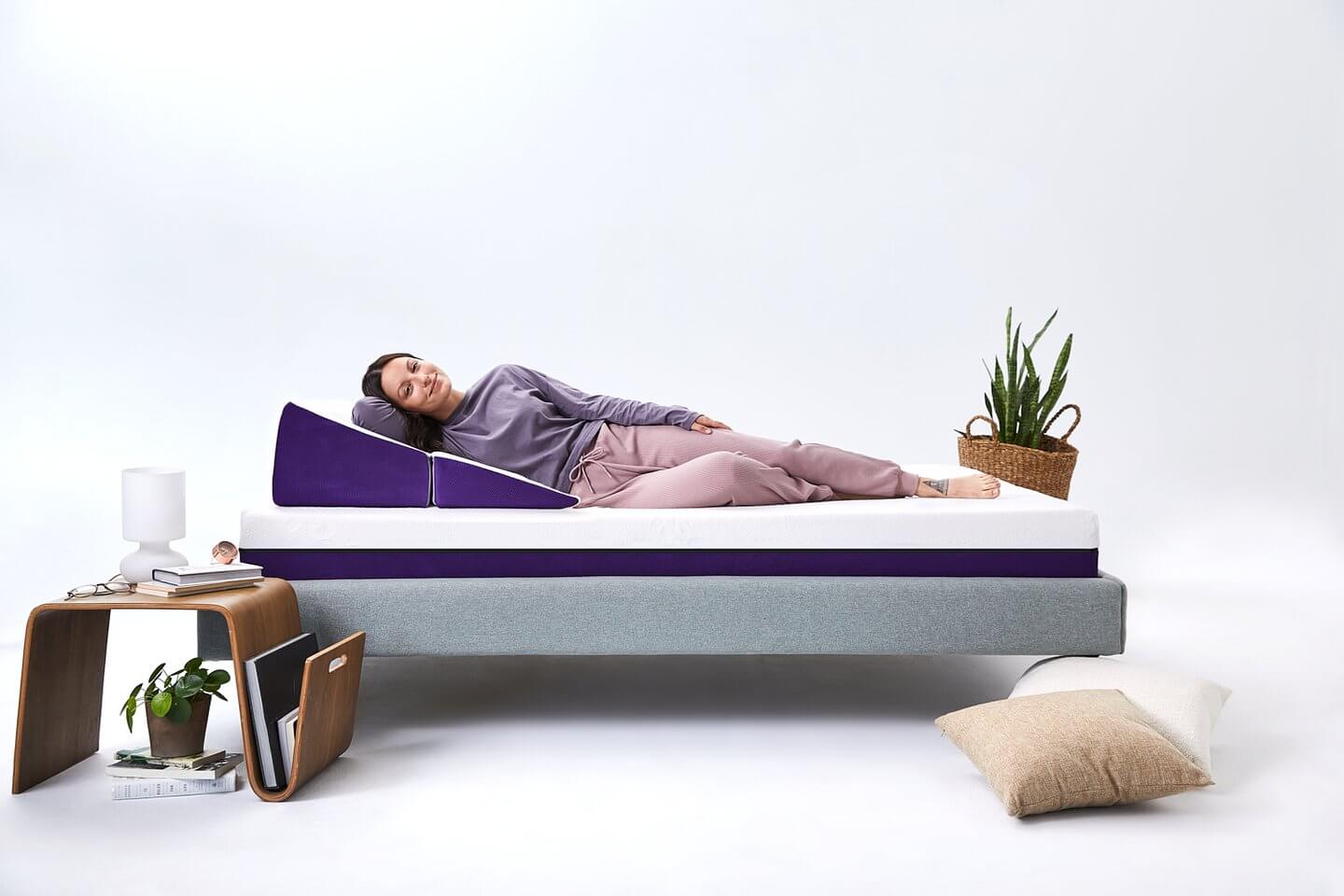 Femme heureuse allongée sur le côté sur l'oreiller triangulaire polysleep