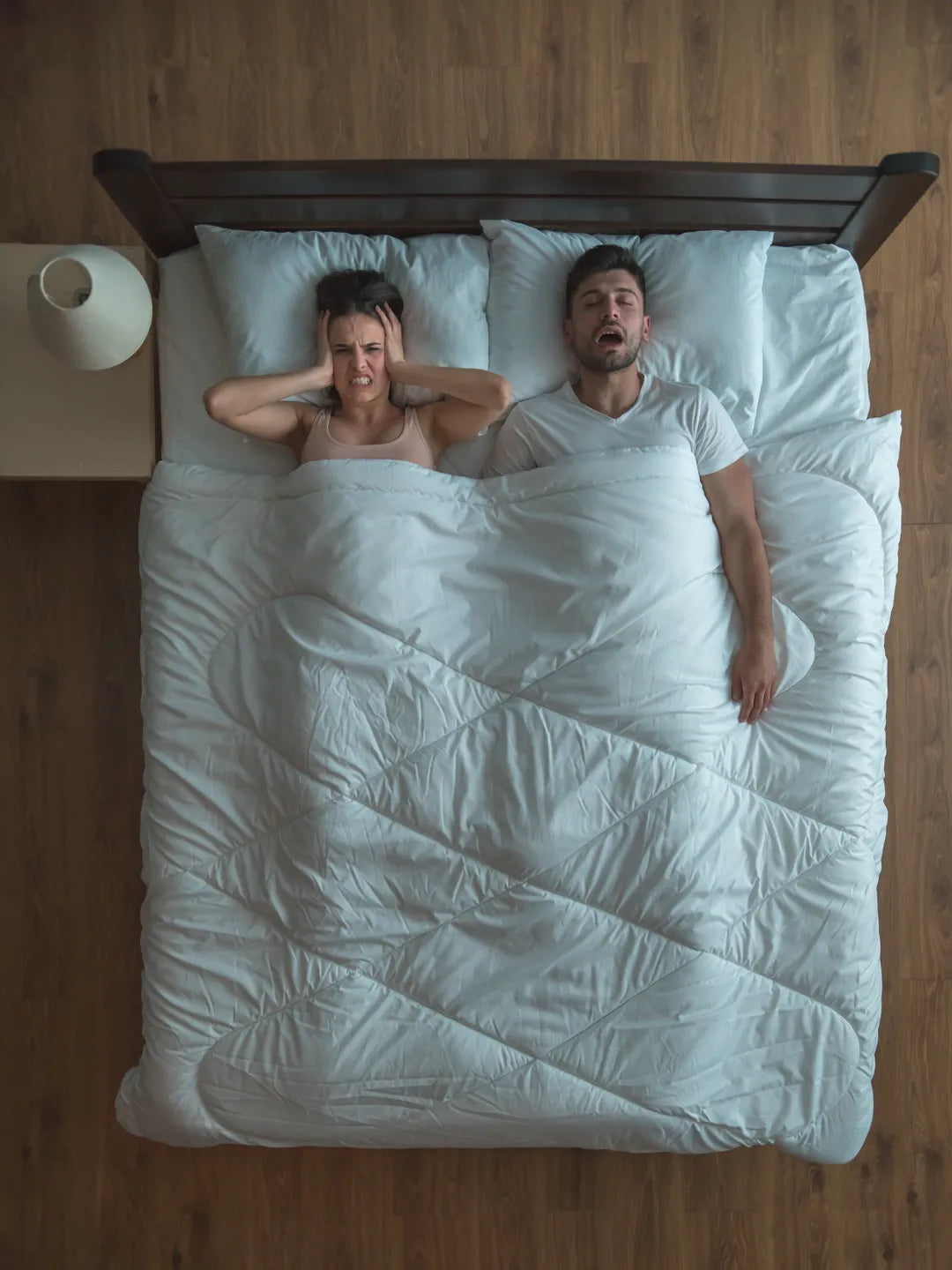 Man with sleep apnea, snore near woman on bed in humid temperature room.