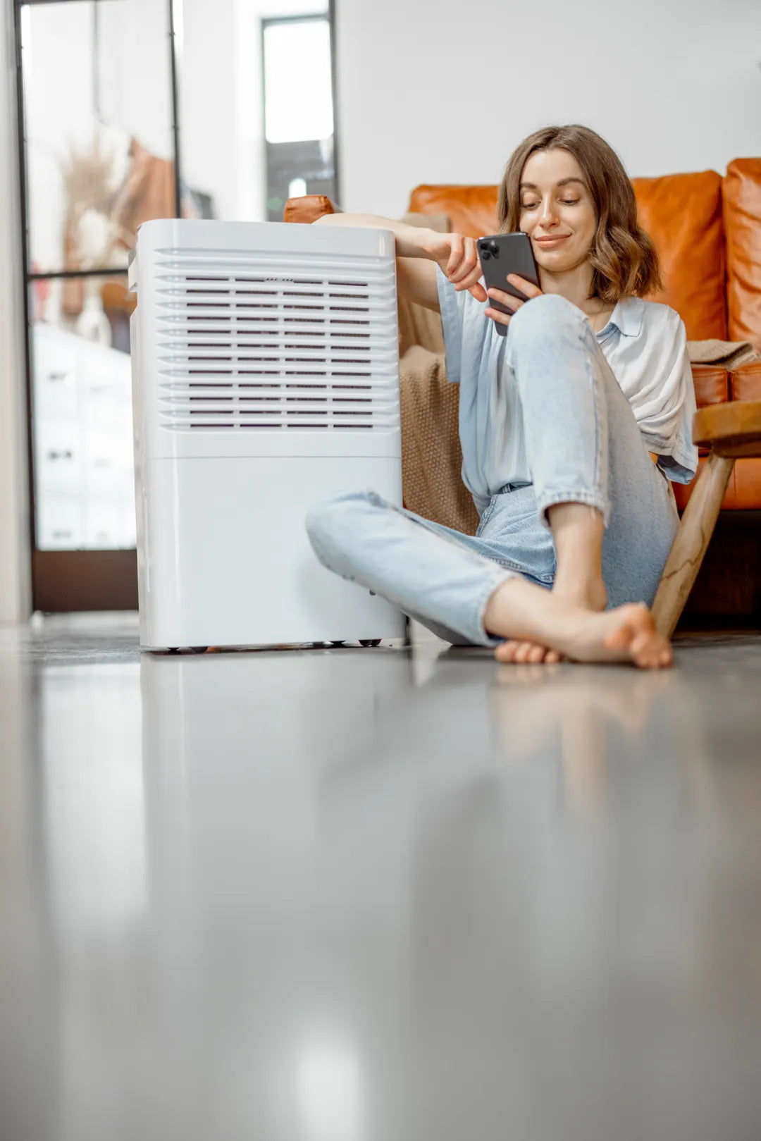 A woman who installed a dehumidifier to reduce the humidity in a room.