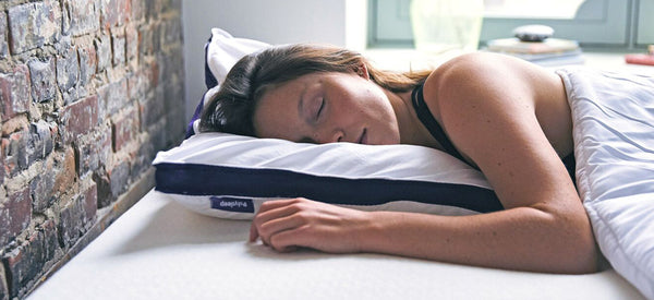 Woman sleeping with her head on top of the Polysleep's adjustable pillow