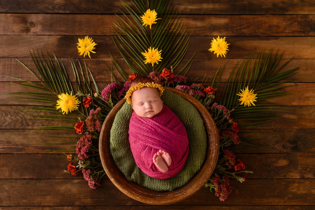 Close-up of a sleeping baby girl wrapped in a purple blanket.