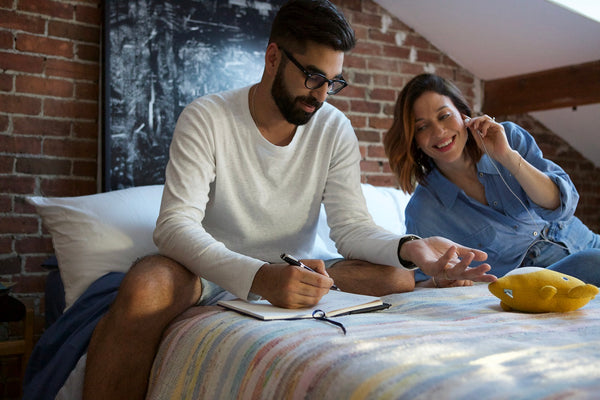 Homme qui prend des notes assis sur son matelas Polysleep