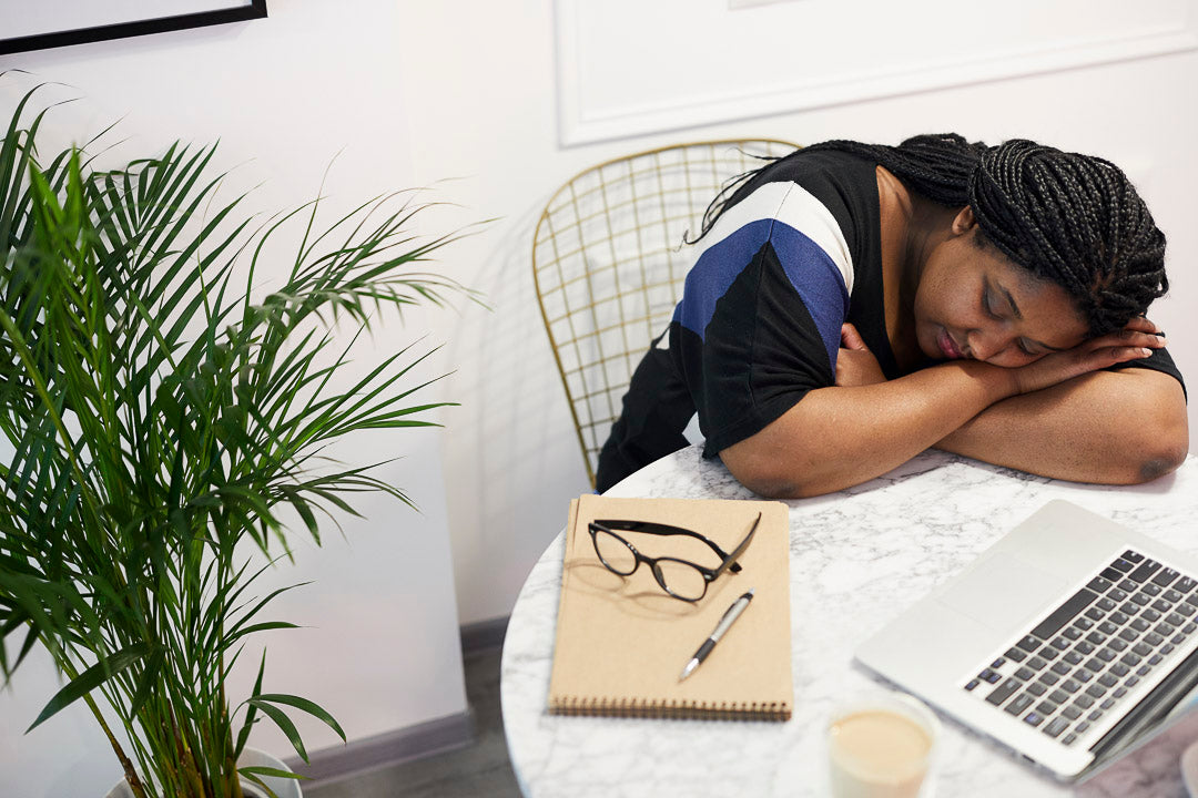 a tired woman with her head resting on the table