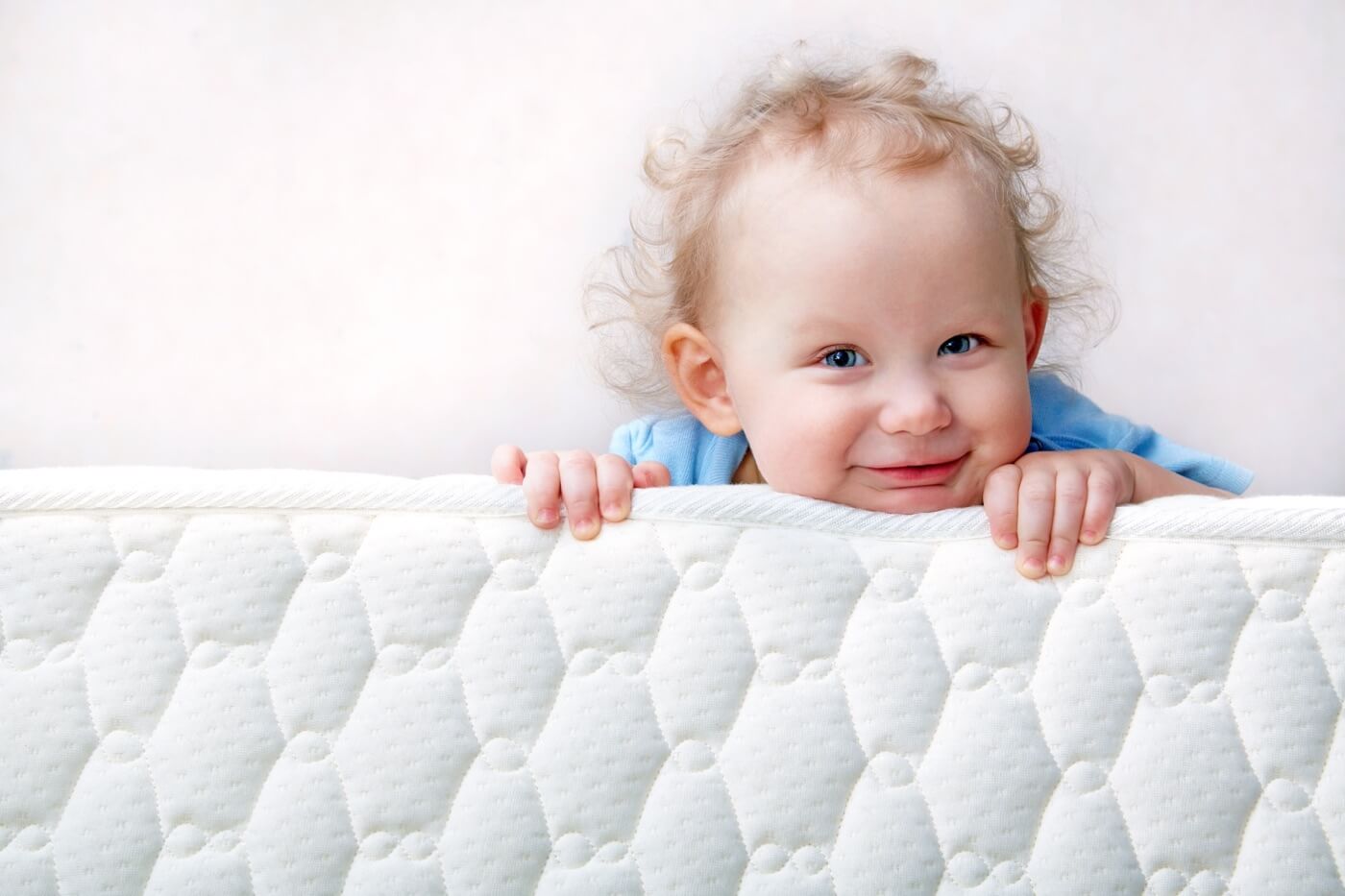 Baby holding the mattress close up