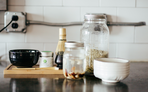contemporary preparation of matcha green tea using homemade nut milk in a modern kitchen
