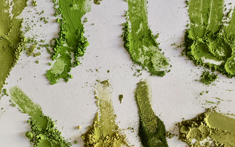 comparison of matcha green teas next to each other during a taste test, on a white piece of paper