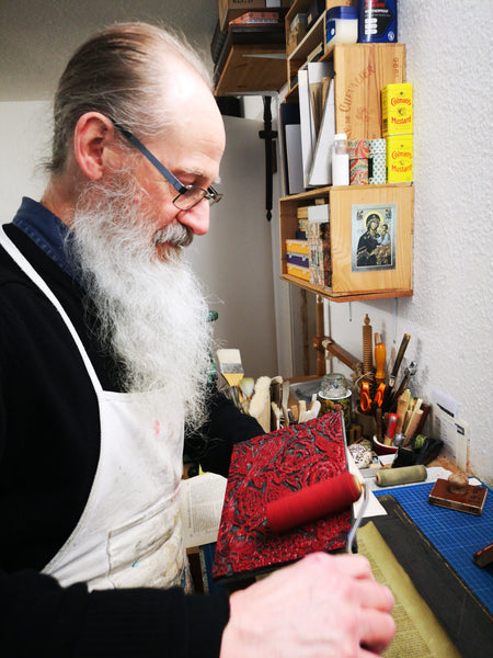 John Jeffery inking a lino block ready for printing