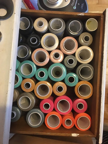 a box filled with many spools of colored threads