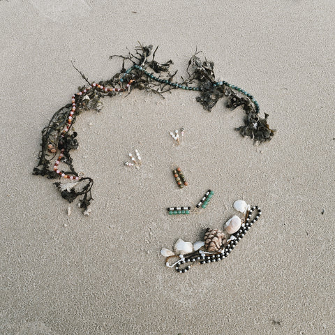 A face made from shells, seaweed and jewellery on the beach