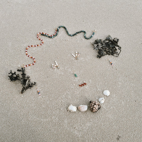 A face made from shells, seaweed and jewellery on the beach