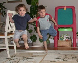 Two boys are jumping over elastic band.