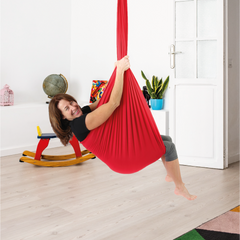 Mothers Day gift Idea - sensory swing - a happy woman enjoying the gentle hug of the red sensory swing