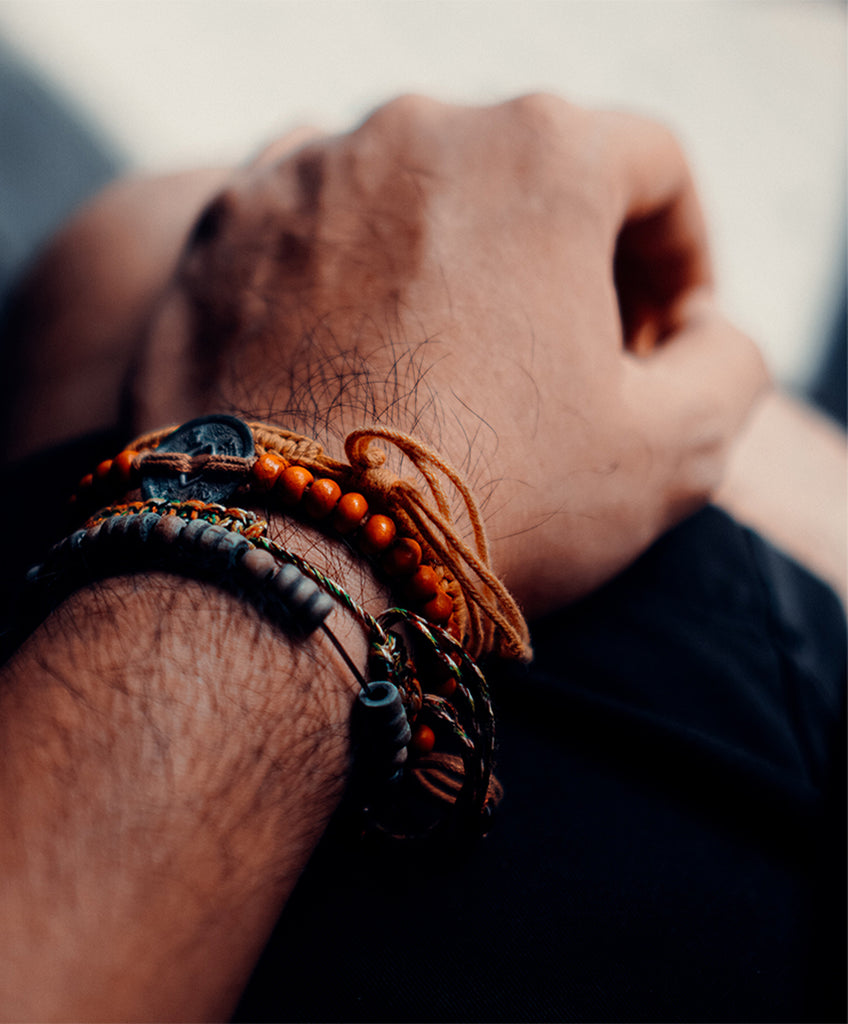 multi color gemstones on man wrist