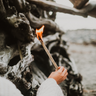 An orange flame burns from the end of an upcycled Abeego firestarter.