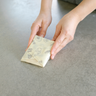 A tightly wrapped block of cheese in a medium Abeego beeswax wrap.