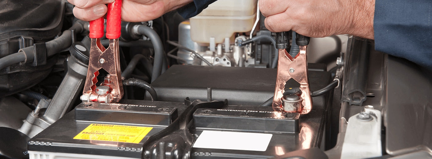 placing jumper cables on car battery to jump start a car