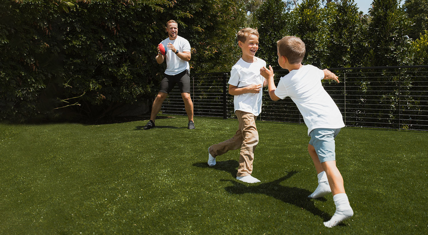 Man playing football with 2 boys