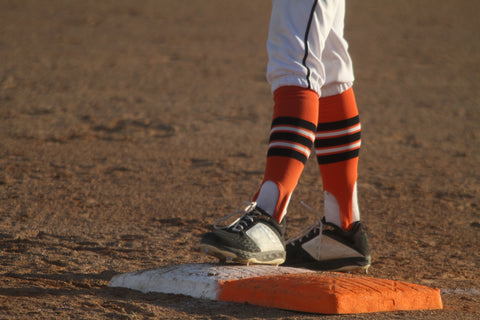 Close up of a player's legs standing on a baseball base