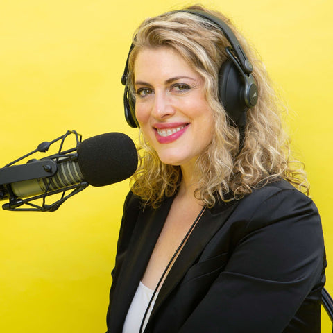 Karen Gross host of She Rocked It microphone yellow background