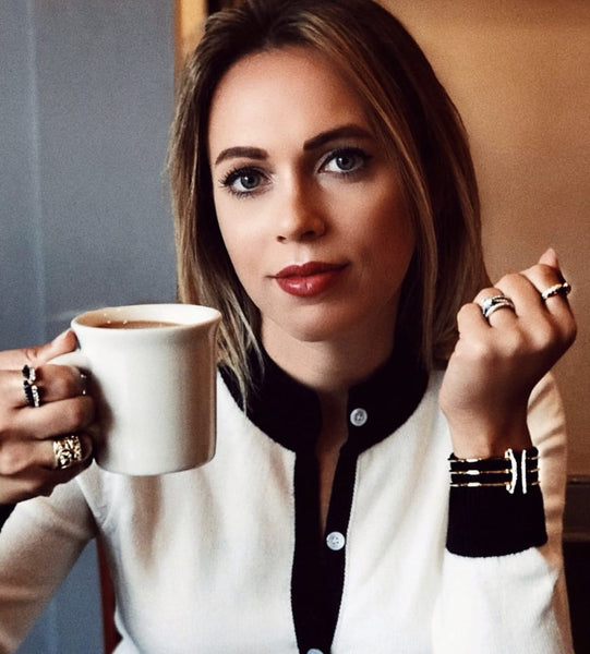 Sarah Zutell with coffee cup wearing REALM stack rings