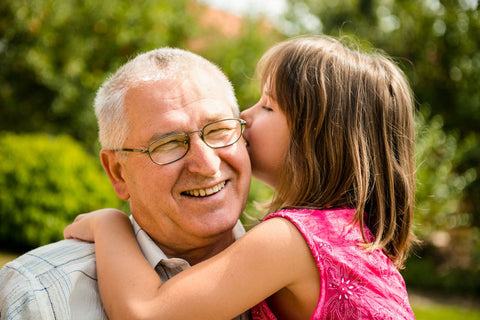 little girl kissing elderly man