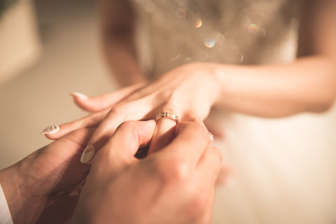 a man puts a wedding ring on a girl's hand