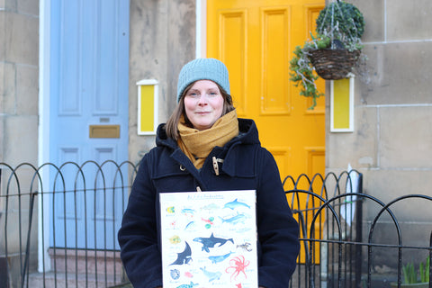 Fiona Purves holding her Sea Creatures illustration