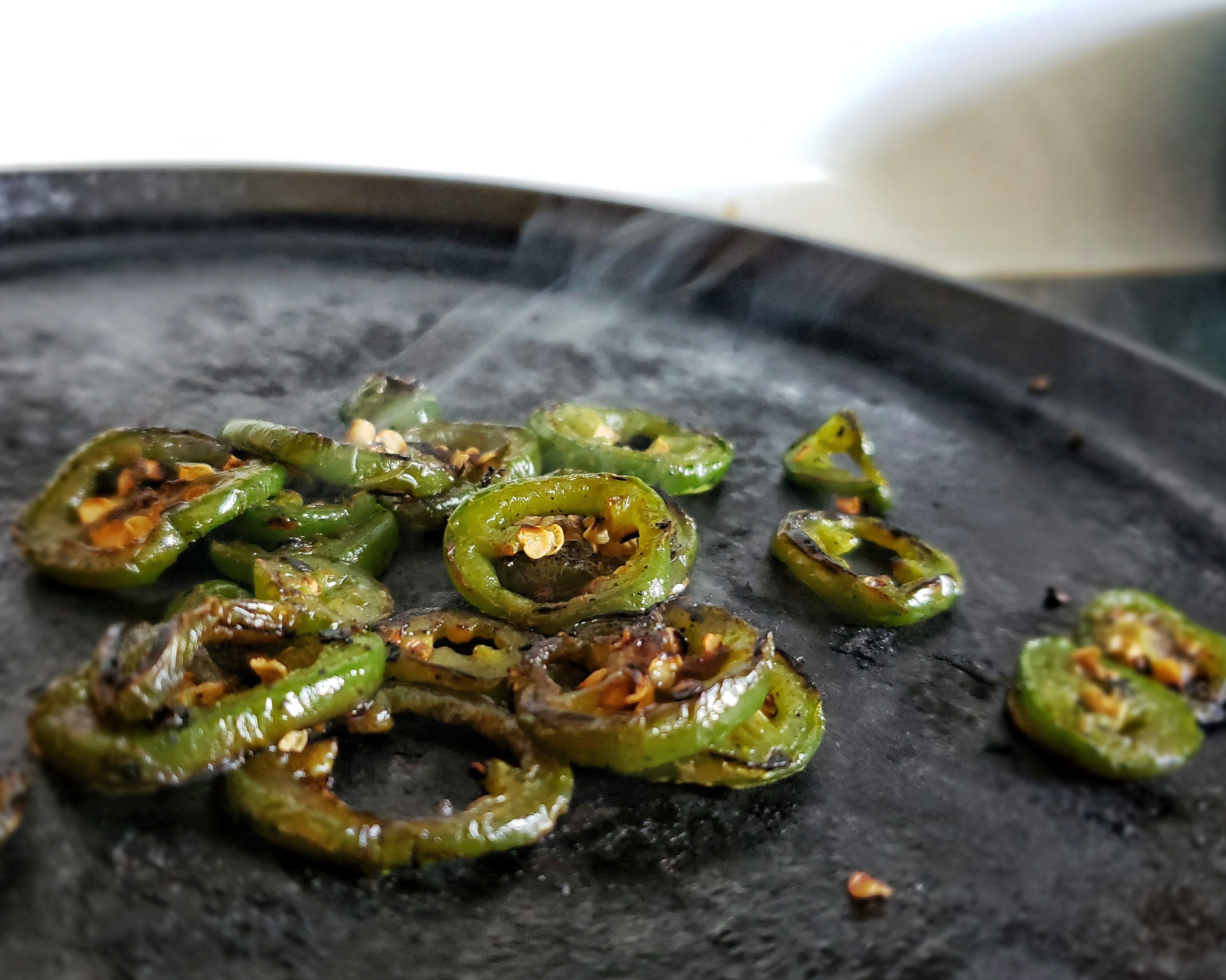 Roasted jalapeno slices on a cast iron comal - socal hot sauce recipes