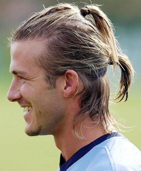 Young David Beckham wearing a double ponytail hairstyle 