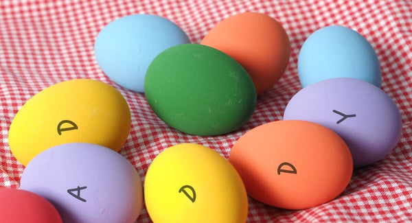 Easter eggs on red fabric spell "DADDY."