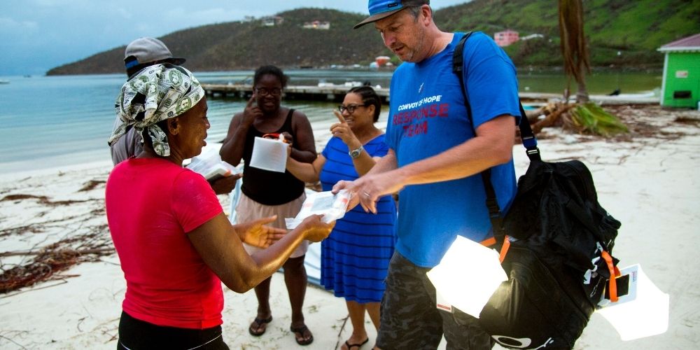 Handing out luminaid at beach after natural disaster