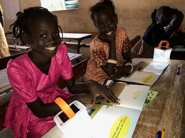 Girls in Senegal reading by LuminAID solar light