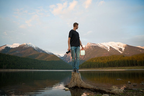 Man with camera and light looking at mountain