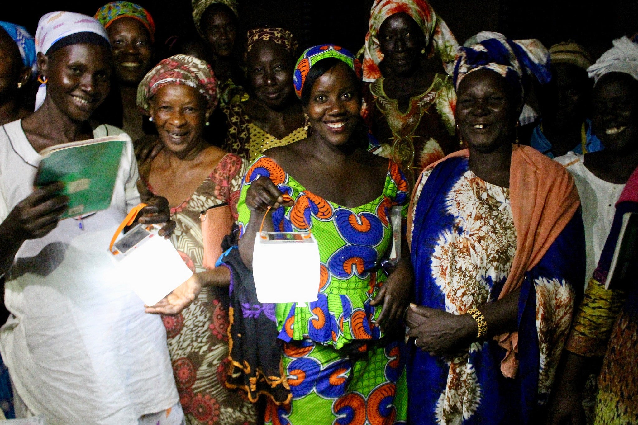 Women in literacy program holding lights.