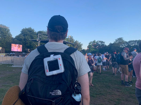 Man traveling with backpack at a festival in daylight